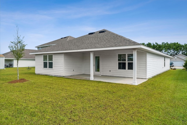 back of property with a yard and a patio