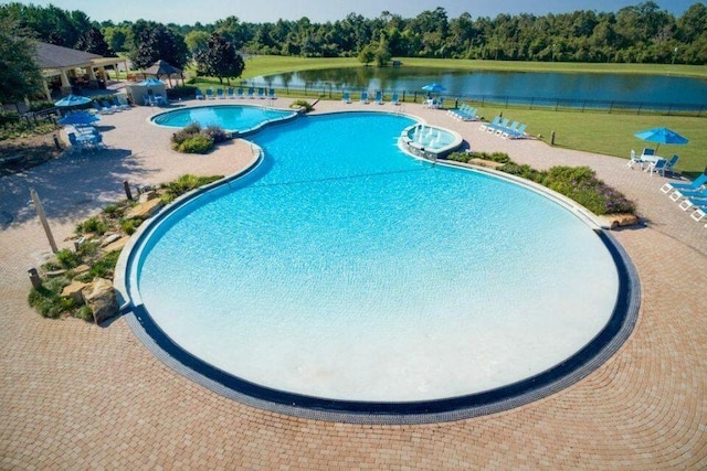 view of swimming pool with a patio and a water view