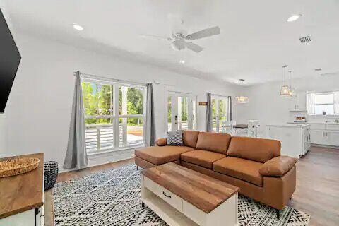 living room with ceiling fan and light wood-type flooring