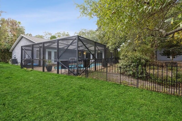 back of property featuring a lanai, central AC, a yard, and a fenced in pool