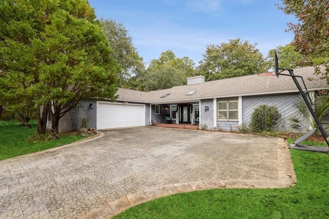 ranch-style home featuring a front lawn and a garage