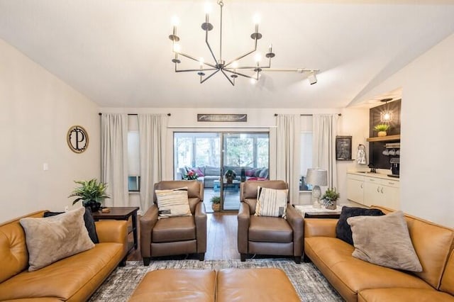 living room featuring a notable chandelier, track lighting, and light hardwood / wood-style flooring