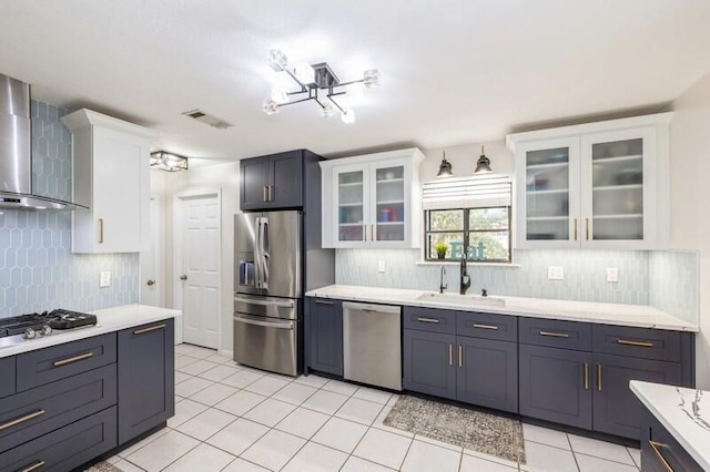 kitchen featuring white cabinetry, appliances with stainless steel finishes, and wall chimney range hood