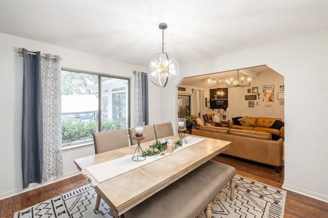 dining space featuring dark hardwood / wood-style floors and a notable chandelier