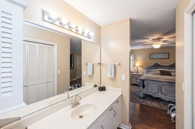 bathroom with hardwood / wood-style floors, vanity, and ceiling fan