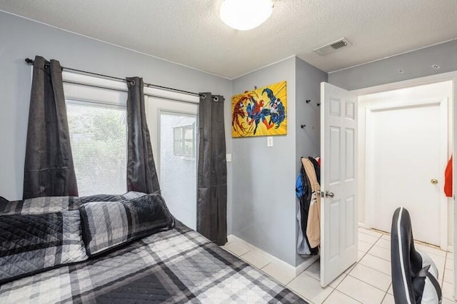 bedroom with light tile patterned floors and a textured ceiling