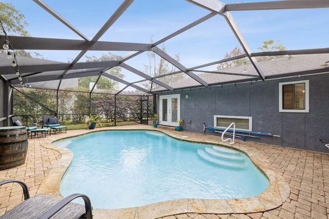 view of pool with a lanai, a patio area, and french doors