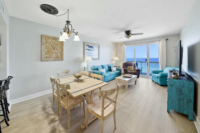 dining area featuring ceiling fan with notable chandelier and light hardwood / wood-style flooring
