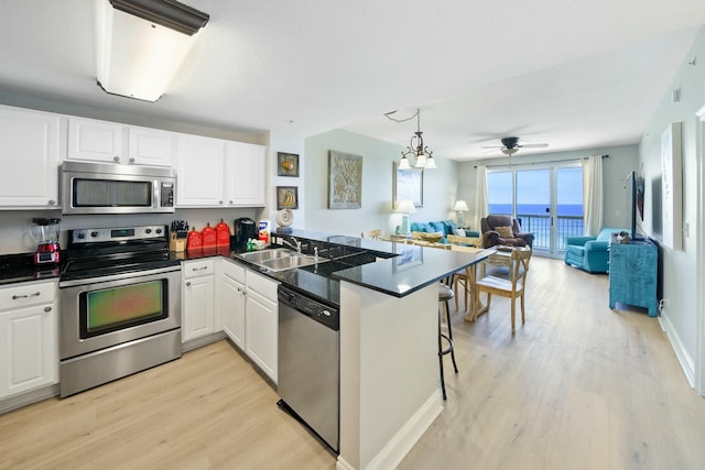 kitchen featuring a breakfast bar area, kitchen peninsula, sink, and stainless steel appliances