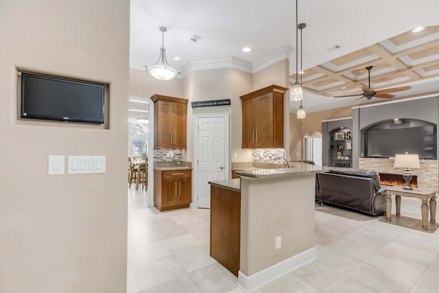 kitchen with kitchen peninsula, tasteful backsplash, ornamental molding, ceiling fan, and pendant lighting