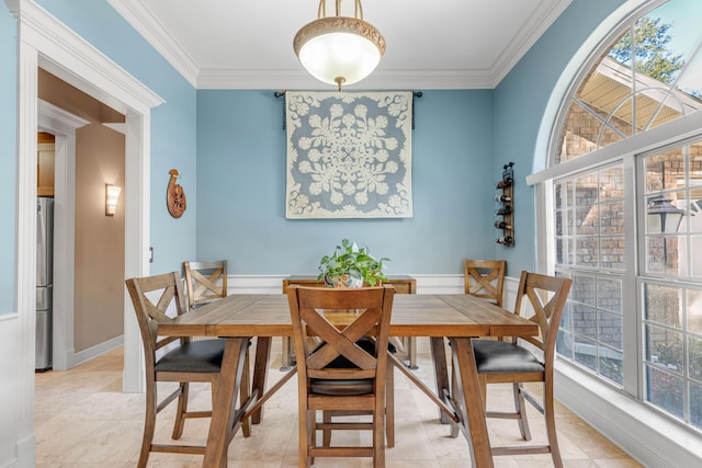 tiled dining area featuring crown molding and a healthy amount of sunlight