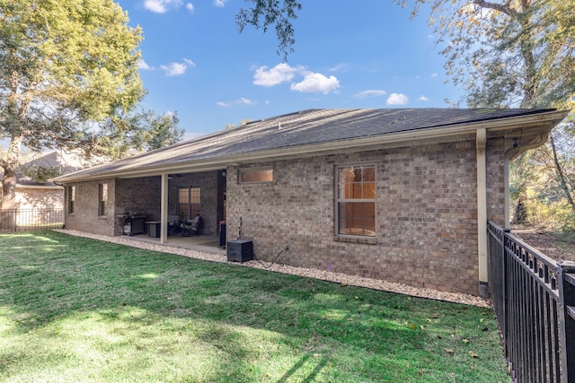 rear view of property with a yard and a patio