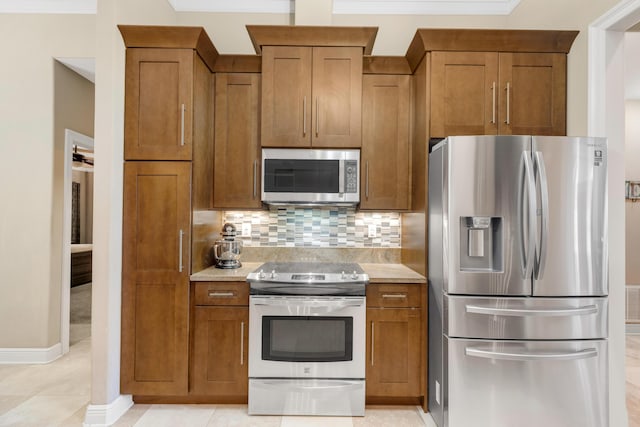 kitchen with decorative backsplash, light tile patterned floors, and stainless steel appliances