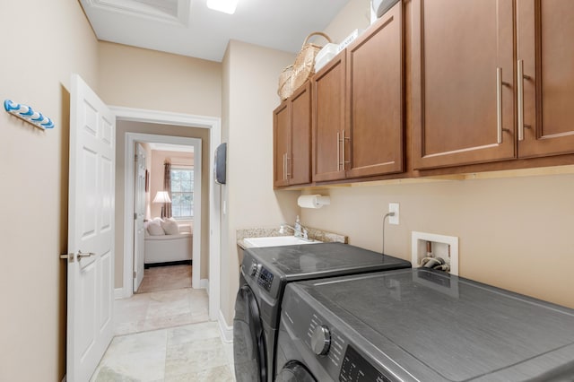 laundry room featuring cabinets, separate washer and dryer, and sink