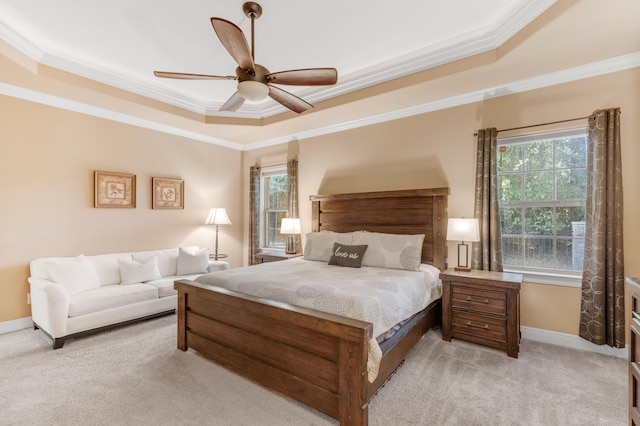 carpeted bedroom featuring a tray ceiling, ceiling fan, and ornamental molding