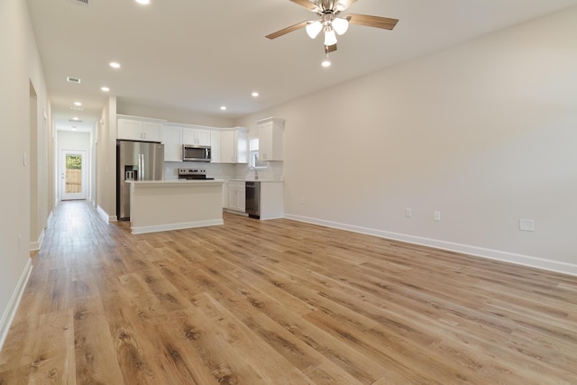 unfurnished living room with ceiling fan and light hardwood / wood-style flooring