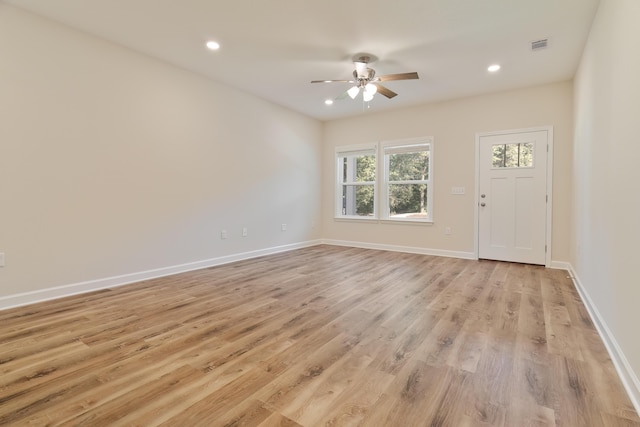 empty room with ceiling fan and light hardwood / wood-style flooring