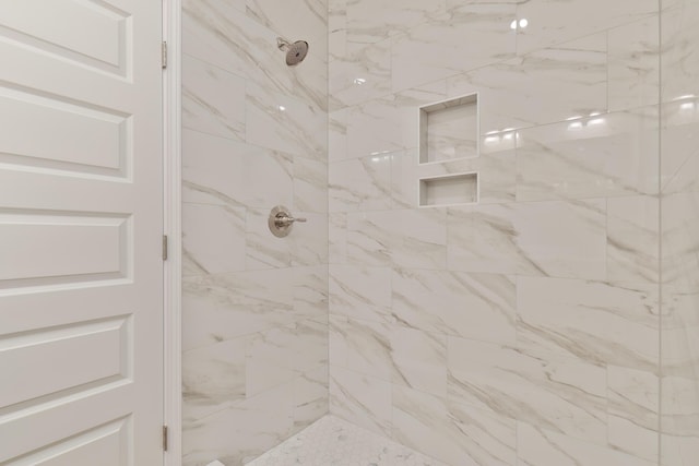 interior details featuring tiled shower