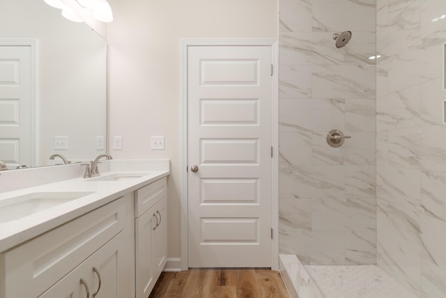 bathroom featuring tiled shower, vanity, and hardwood / wood-style flooring