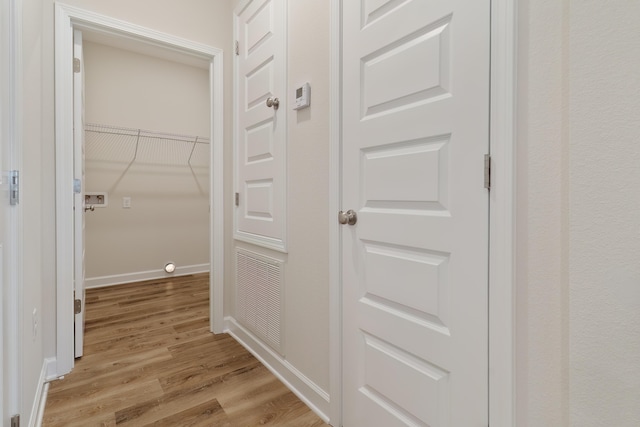 hallway with light hardwood / wood-style floors