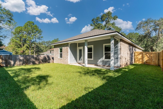 rear view of property featuring a patio area and a lawn