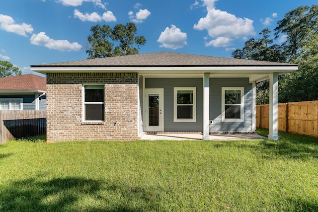 rear view of property with a yard