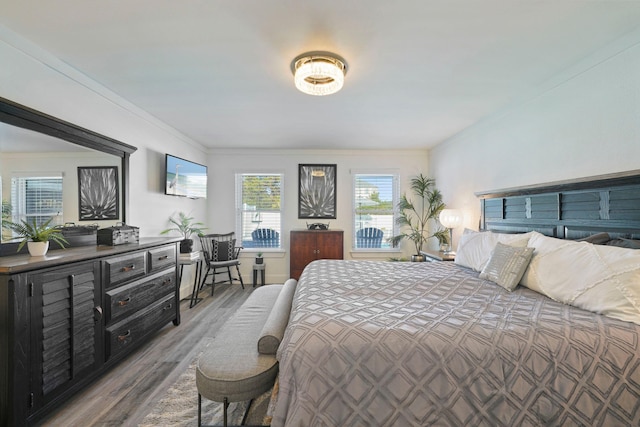 bedroom featuring wood-type flooring and ornamental molding