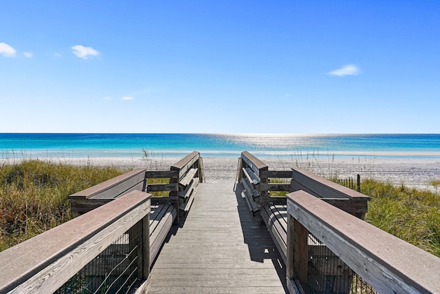 view of home's community with a water view and a beach view