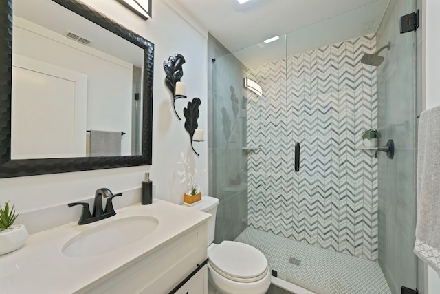 bathroom with vanity, an enclosed shower, and toilet