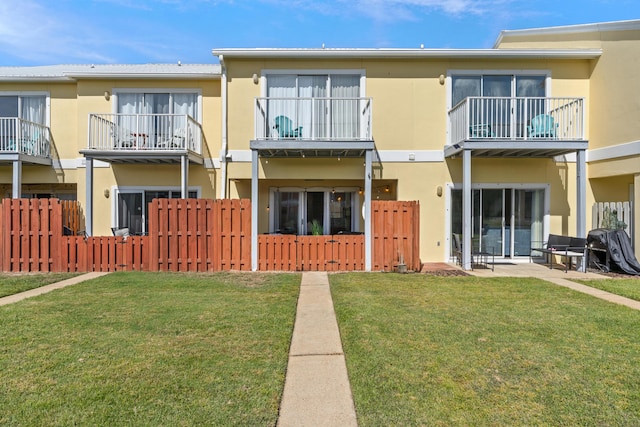 rear view of property with a lawn and a patio