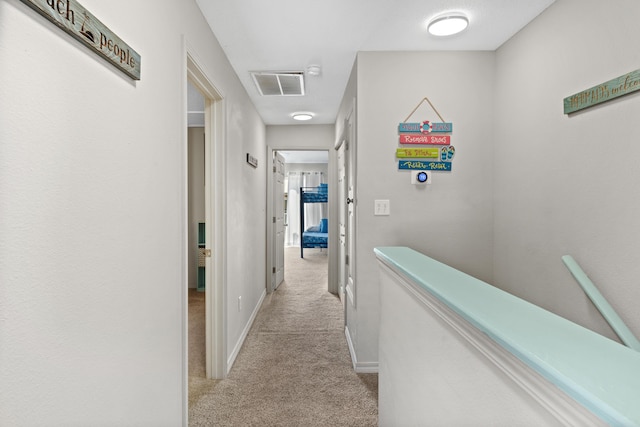 hallway featuring light colored carpet