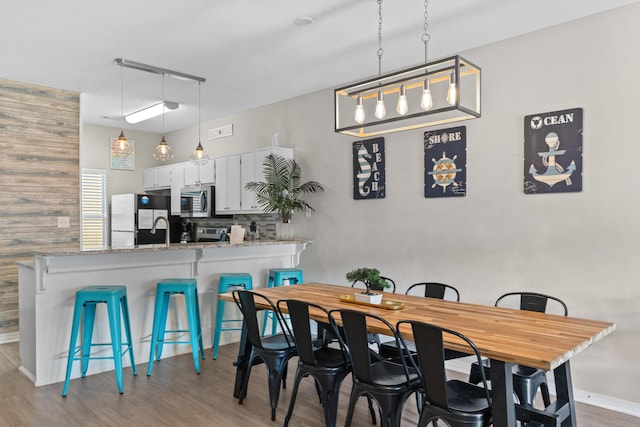 dining space featuring light hardwood / wood-style flooring and sink