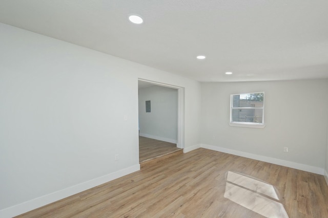 empty room featuring light wood-type flooring and vaulted ceiling