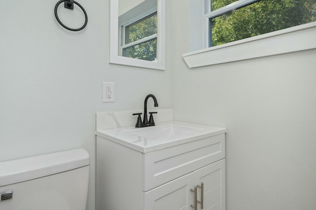 bathroom with vanity, a healthy amount of sunlight, and toilet