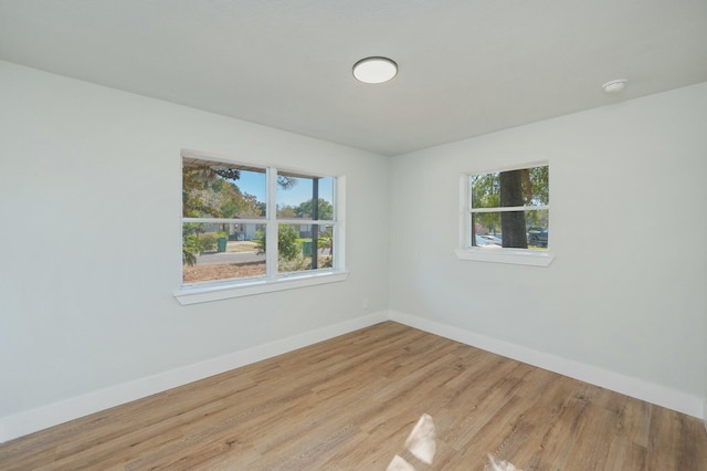 unfurnished room featuring a healthy amount of sunlight and light wood-type flooring