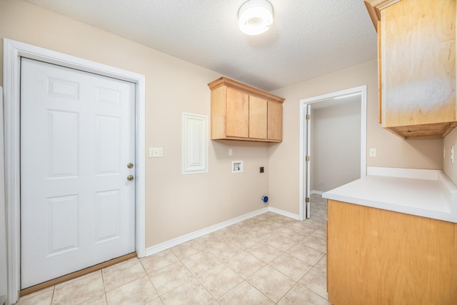 washroom with cabinets, electric dryer hookup, hookup for a washing machine, a textured ceiling, and light tile patterned flooring