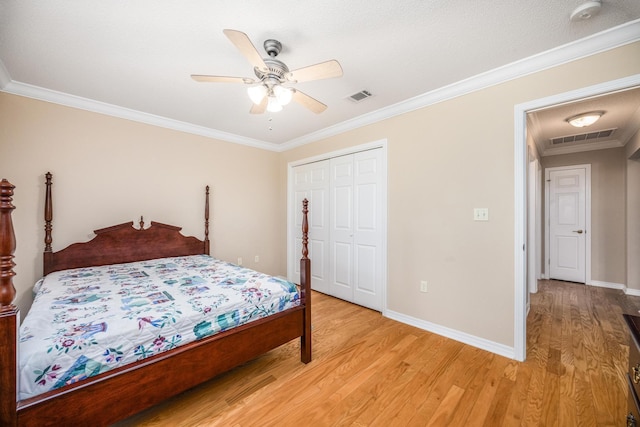 bedroom featuring ceiling fan, light wood-type flooring, a textured ceiling, a closet, and ornamental molding