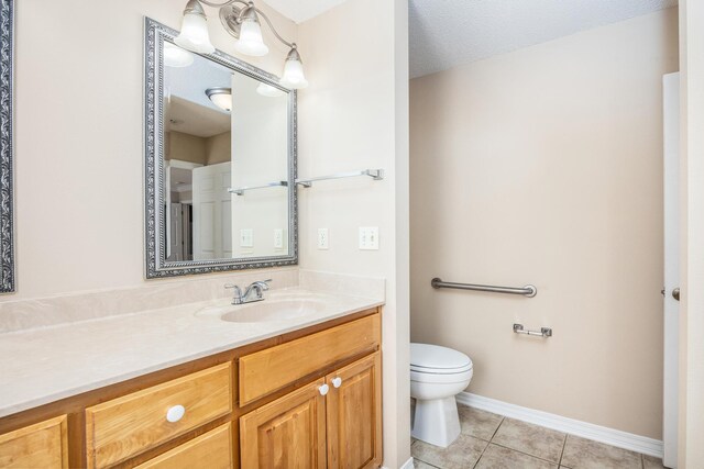 bathroom featuring vanity, a textured ceiling, tile patterned floors, and toilet