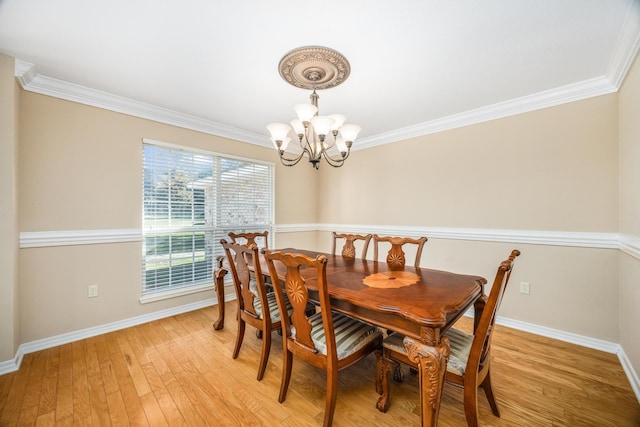 dining area featuring a notable chandelier, light hardwood / wood-style floors, and crown molding