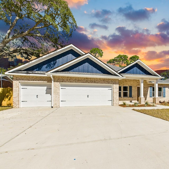 view of front of property featuring a garage, driveway, board and batten siding, and brick siding