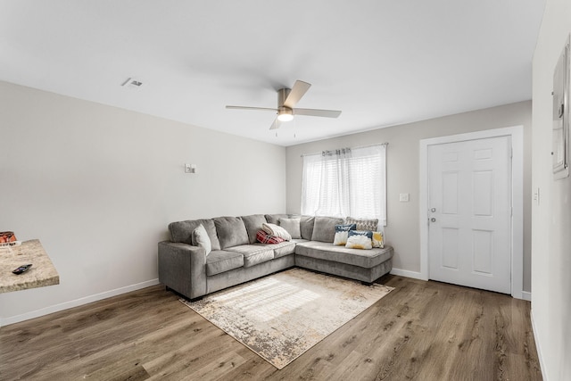 living room with wood-type flooring and ceiling fan