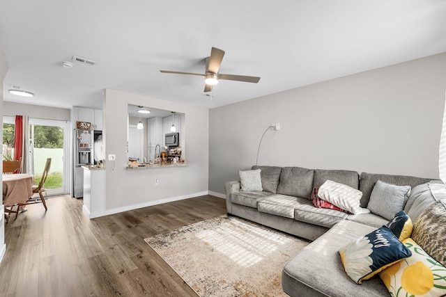 living room featuring wood-type flooring and ceiling fan