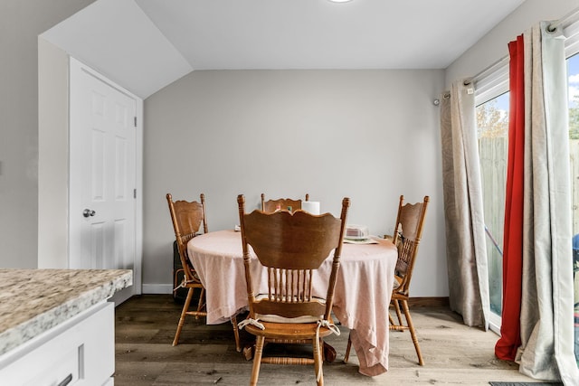 dining area with lofted ceiling and dark wood-type flooring