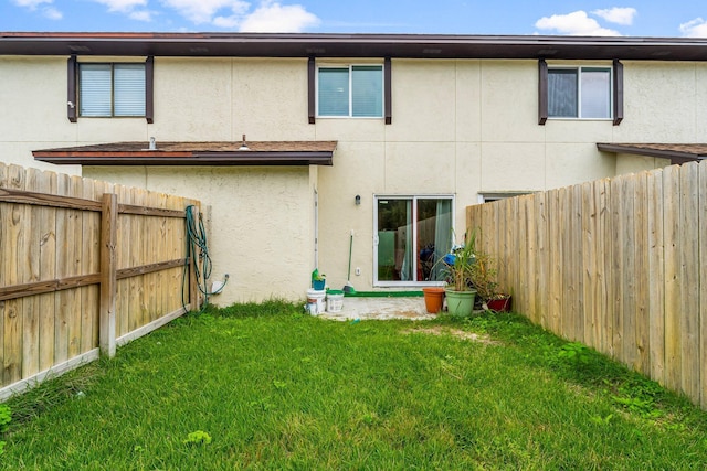 rear view of house featuring a yard