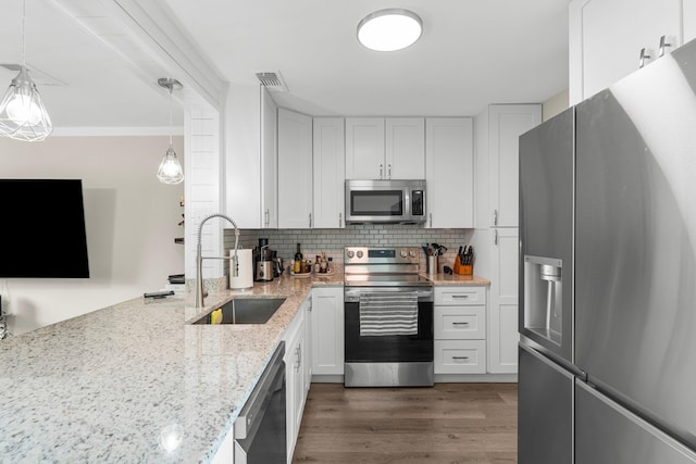 kitchen featuring pendant lighting, sink, dark hardwood / wood-style flooring, white cabinetry, and stainless steel appliances