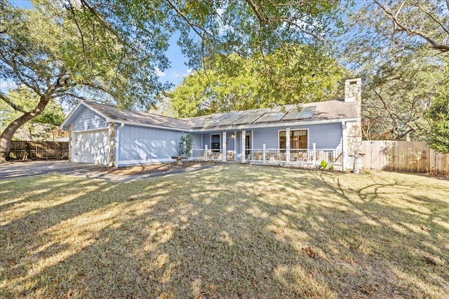 ranch-style home with solar panels, a porch, a garage, and a front lawn