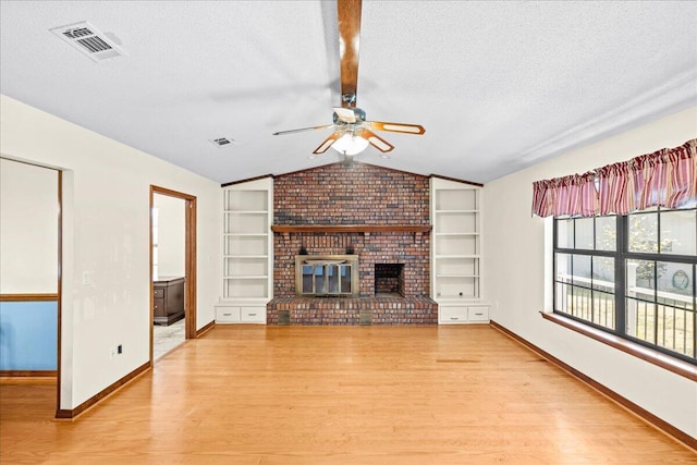 unfurnished living room featuring vaulted ceiling, a fireplace, light hardwood / wood-style floors, and a textured ceiling