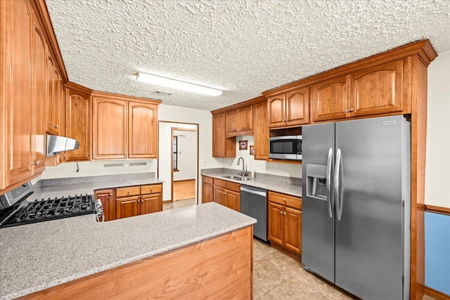 kitchen with sink, stainless steel appliances, range hood, kitchen peninsula, and a textured ceiling