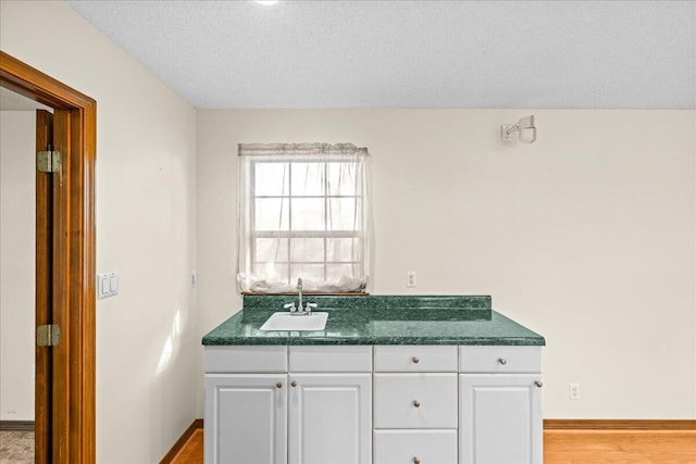 bathroom with vanity, wood-type flooring, and a textured ceiling