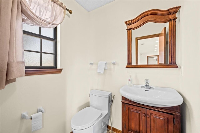 bathroom with vanity, a textured ceiling, and toilet